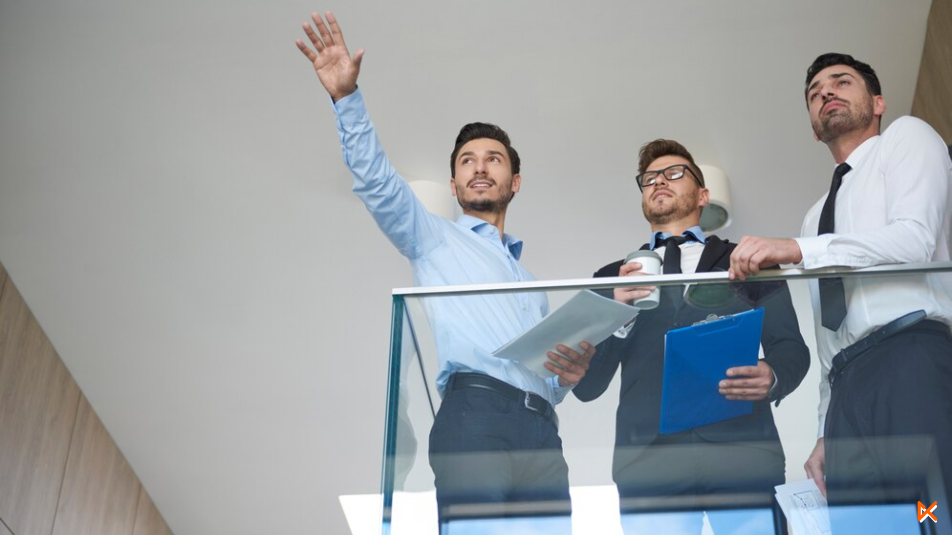 3 hombres de traje mirando hacia el horizonte con peles importantes en mano